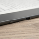 A close-up of the Kindle Scribe's sleep/wake button and USB-C port on the side of the device sitting on a wooden table.